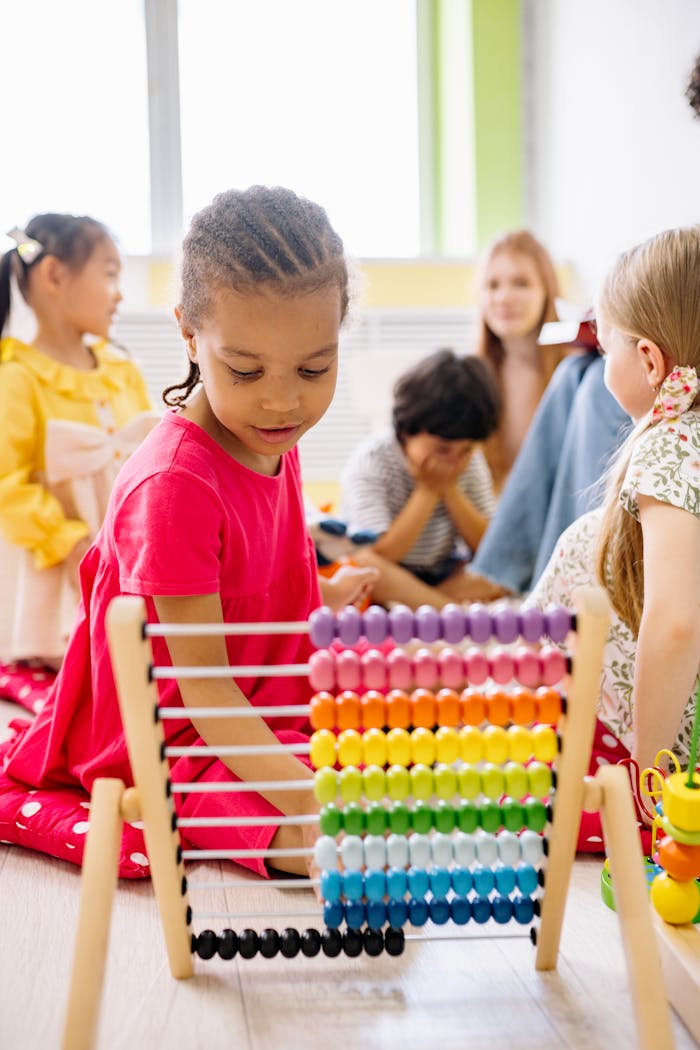 Happy children exploring an abacus in a lively classroom setting.